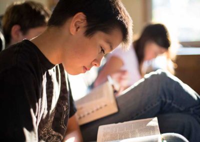A boy studying the scriptures in seminary.